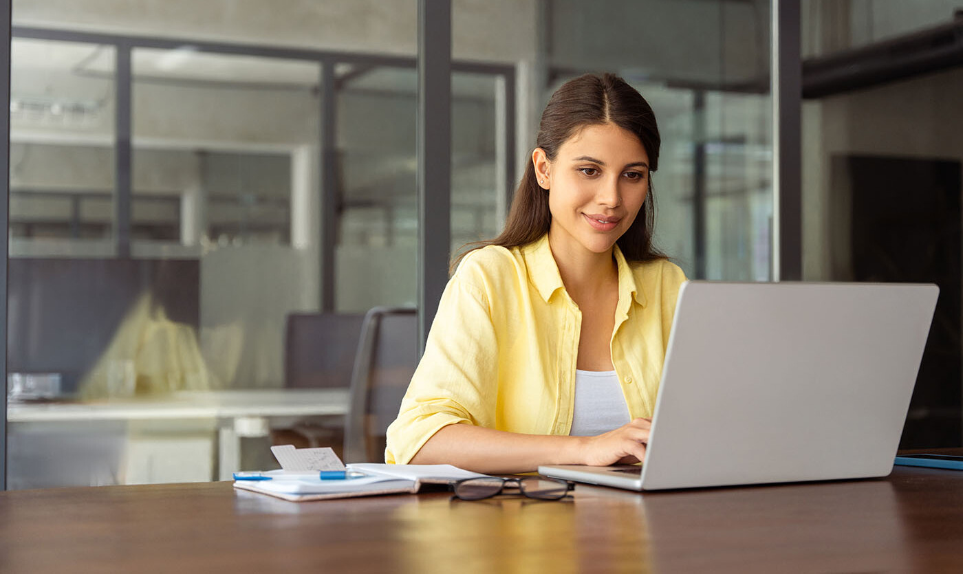 Frau im Büro am Laptop Frau am Schreibtisch vorm Bildschirm