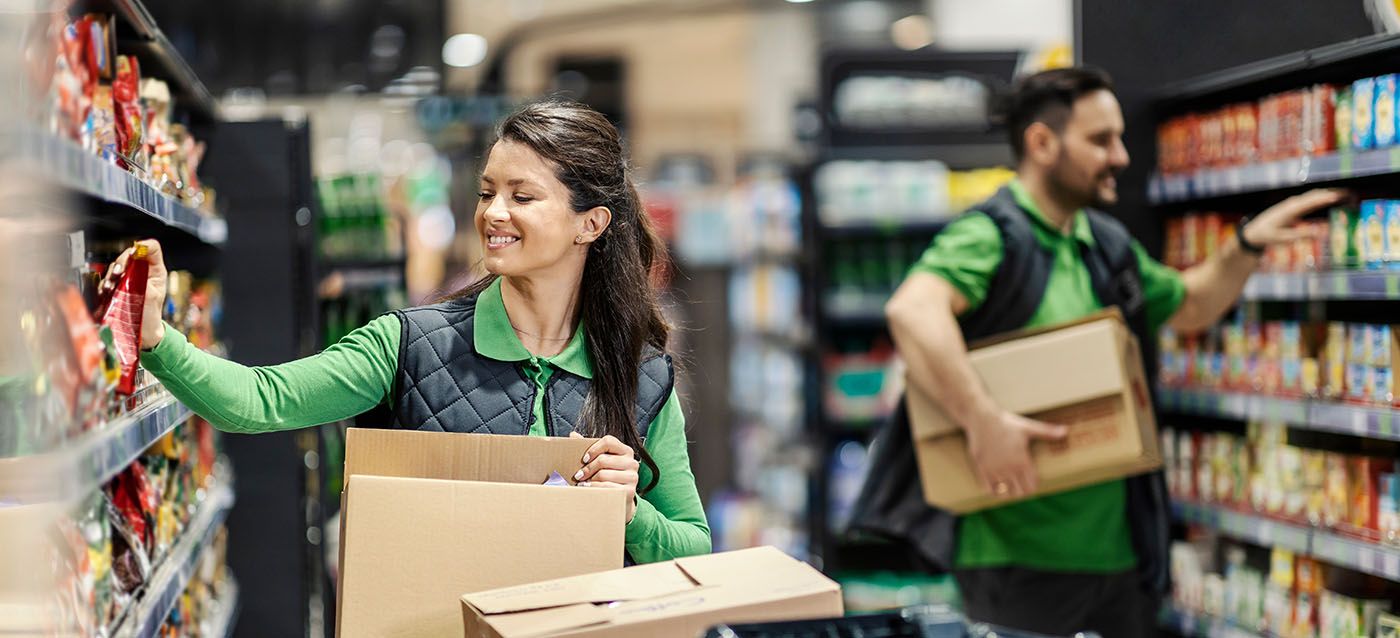 Beschäftigte, die Waren im Supermarkt einräumen
