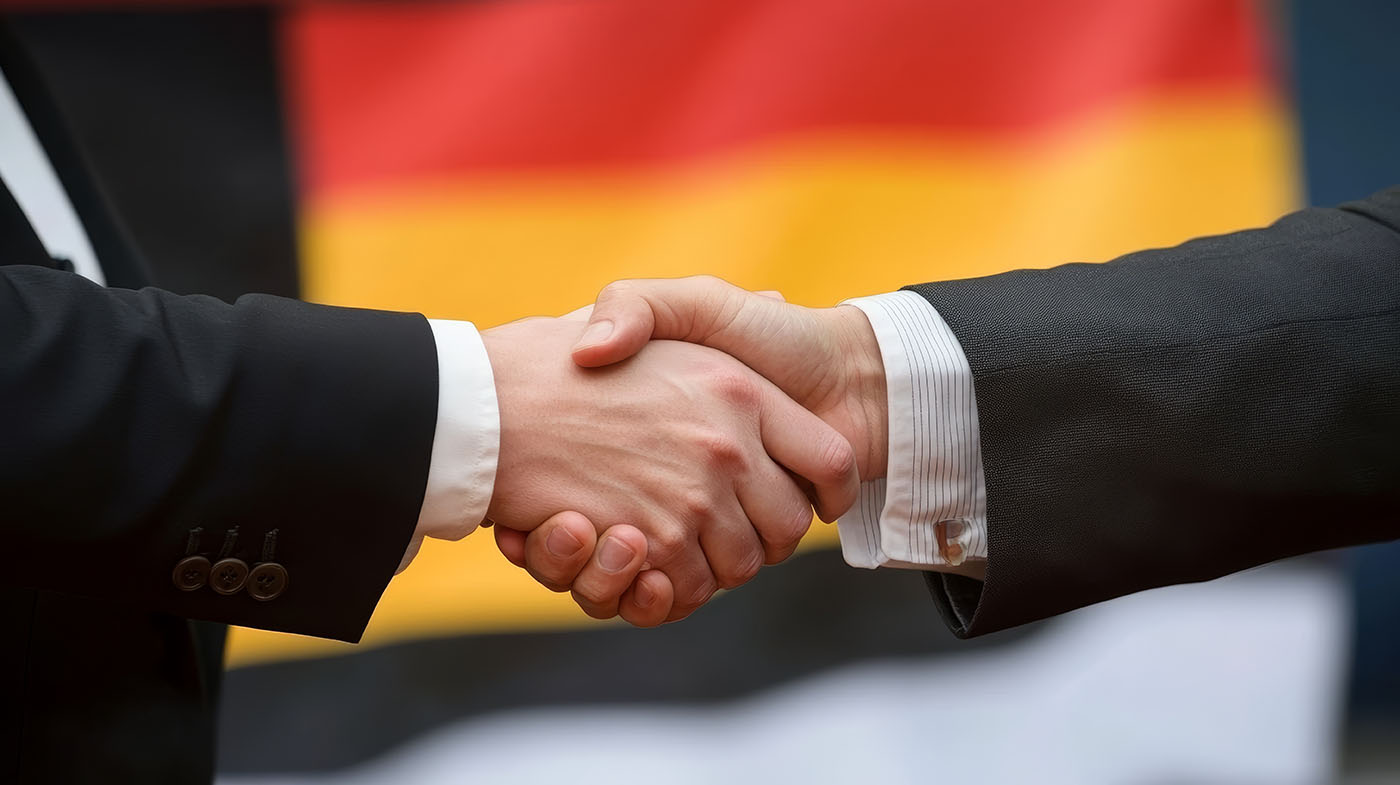 Hände geben vor der Deutschlandflagge