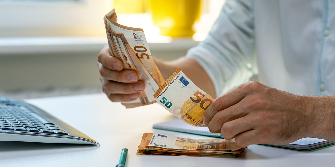 Mann im Büro, der Geldscheine zählt